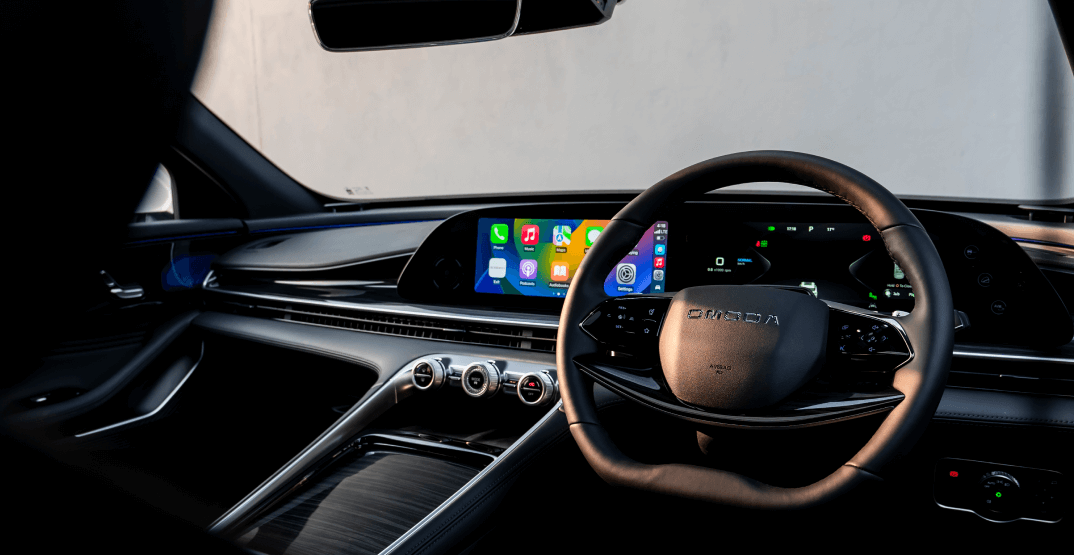 Omoda C9 SUV interior with dual-screen dashboard, digital controls, and modern black trim.